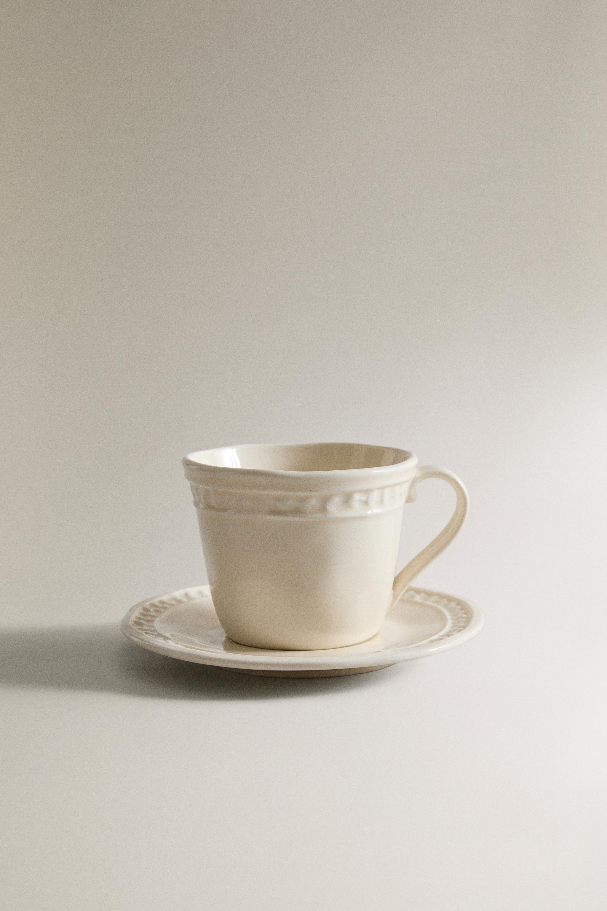 STONEWARE RAISED DESIGN COFFEE CUP AND SAUCER